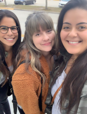 Three young friends smiling at the camera.