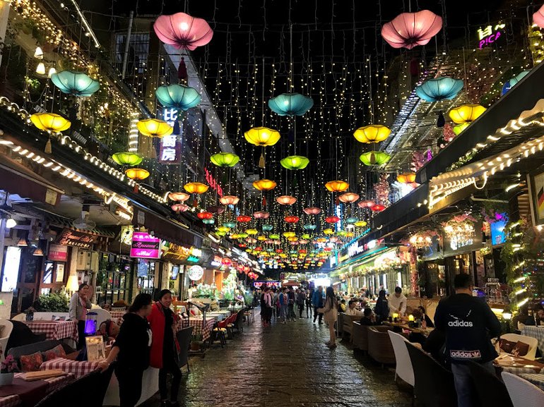 Colorful lights hanging above a row of restaurants in China.