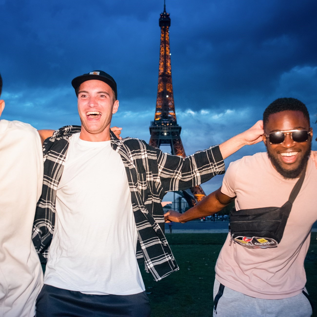 Two young friends laughing in front of the Eiffel Tower in Paris, France.