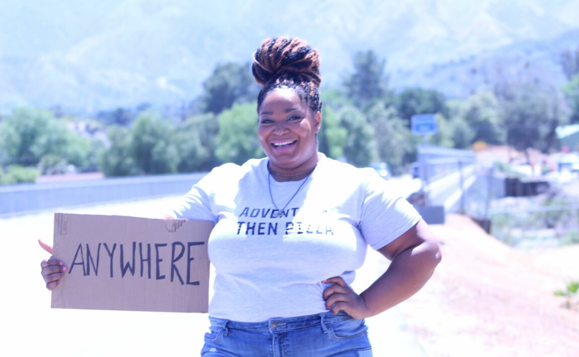 A woman promoting body positivity by holding up a sign that says i'm here for you.
