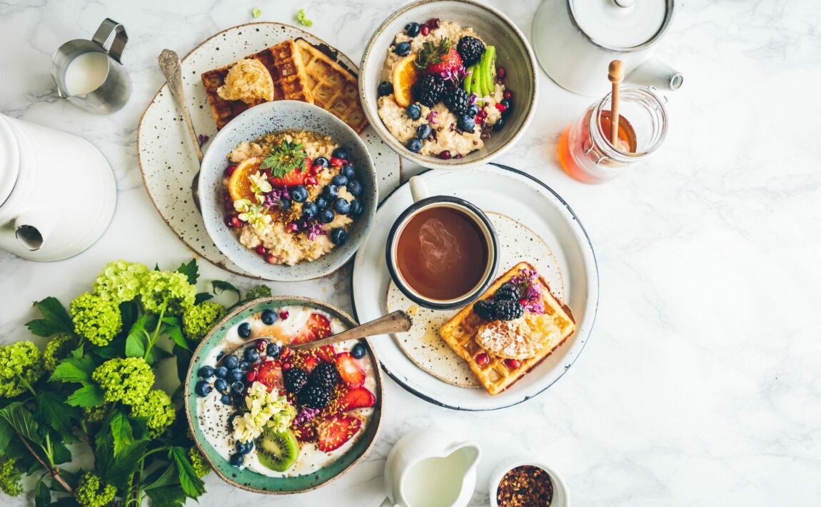 Vegan breakfast with waffles and fruit on a marble table.