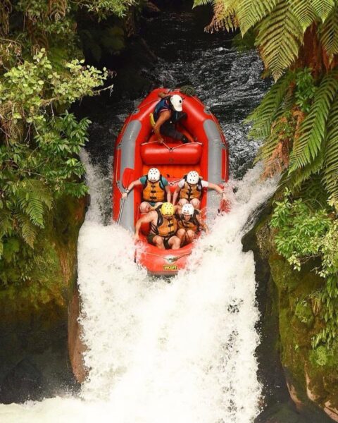 Group of Contiki travellers on inflatable rafts posing for a picture on the Kaituna river