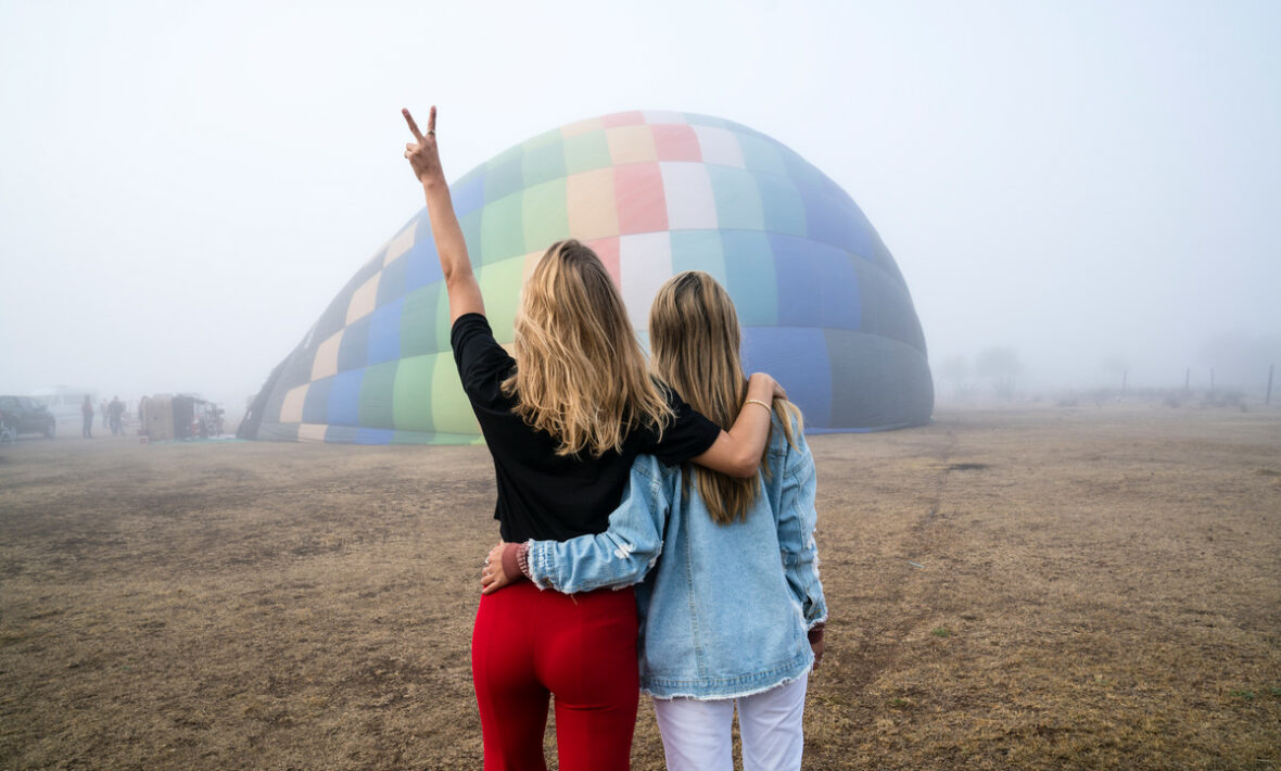 Two LGBTQ women enjoying a hot air balloon adventure.