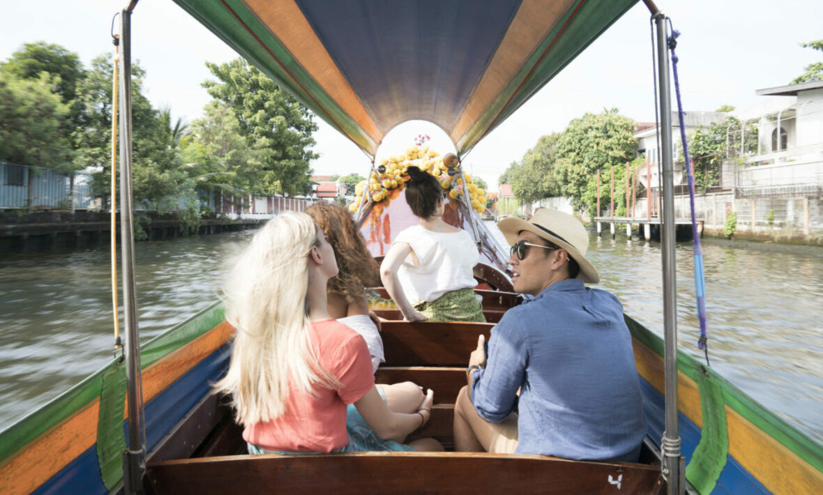 A group of people traveling down a canal in Asia.