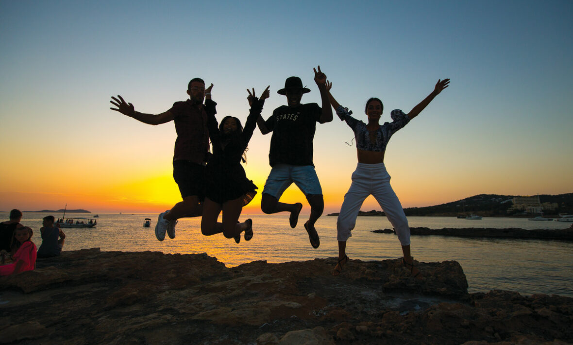 A group of first time travellers jumping in the air.