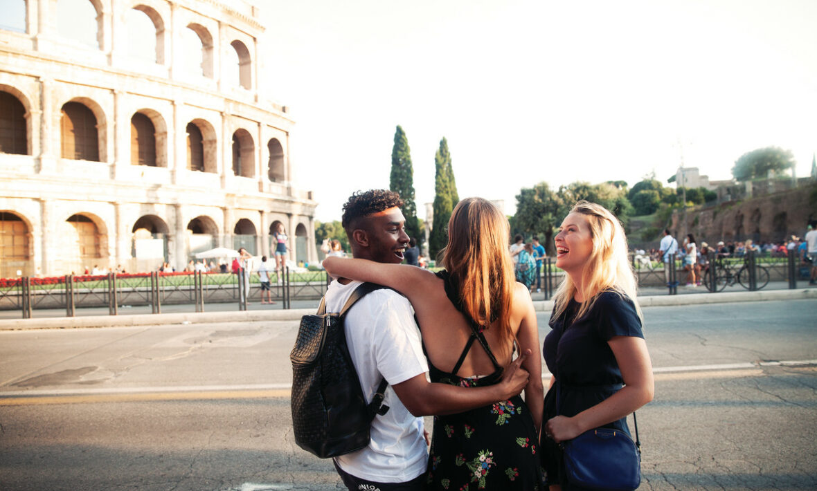 Three friends exploring Europe with Contiki standing in front of the Colosseum in Rome, Italy.