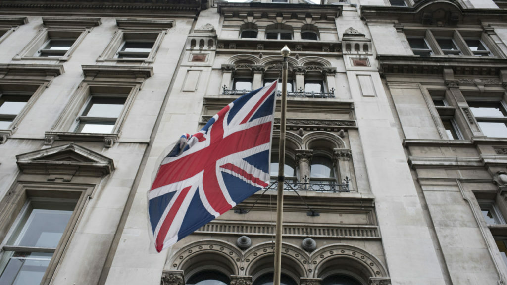 A British flag flies in front of a building in London, showcasing the country's rich music history.