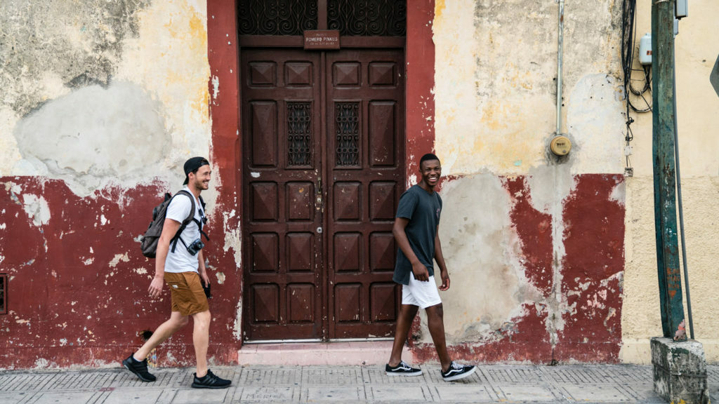 Two young men strolling through a street in Havana during their Latin America adventure with Contiki.