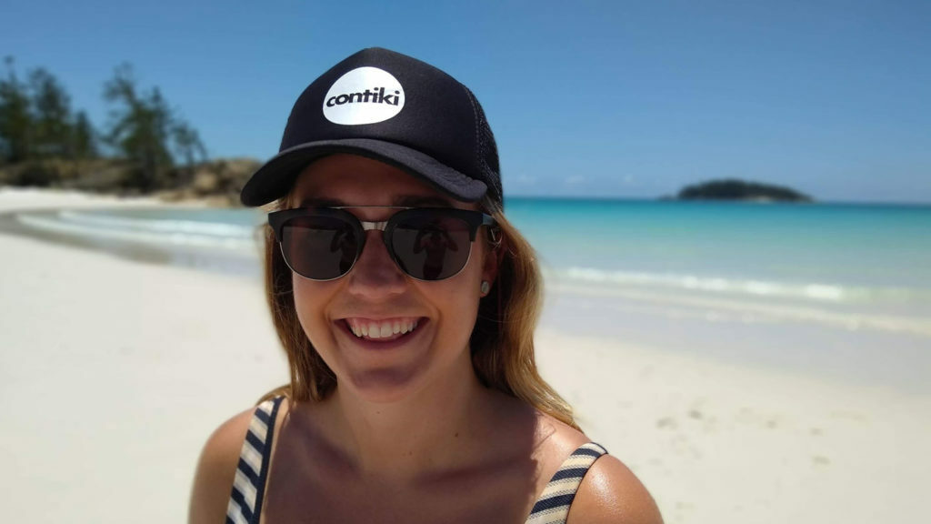 A woman wearing sunglasses and a hat on a Contiki trip in Australia.