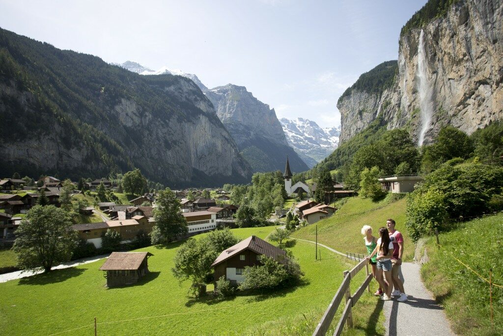 Two people walking down a path in the Swiss Alps.