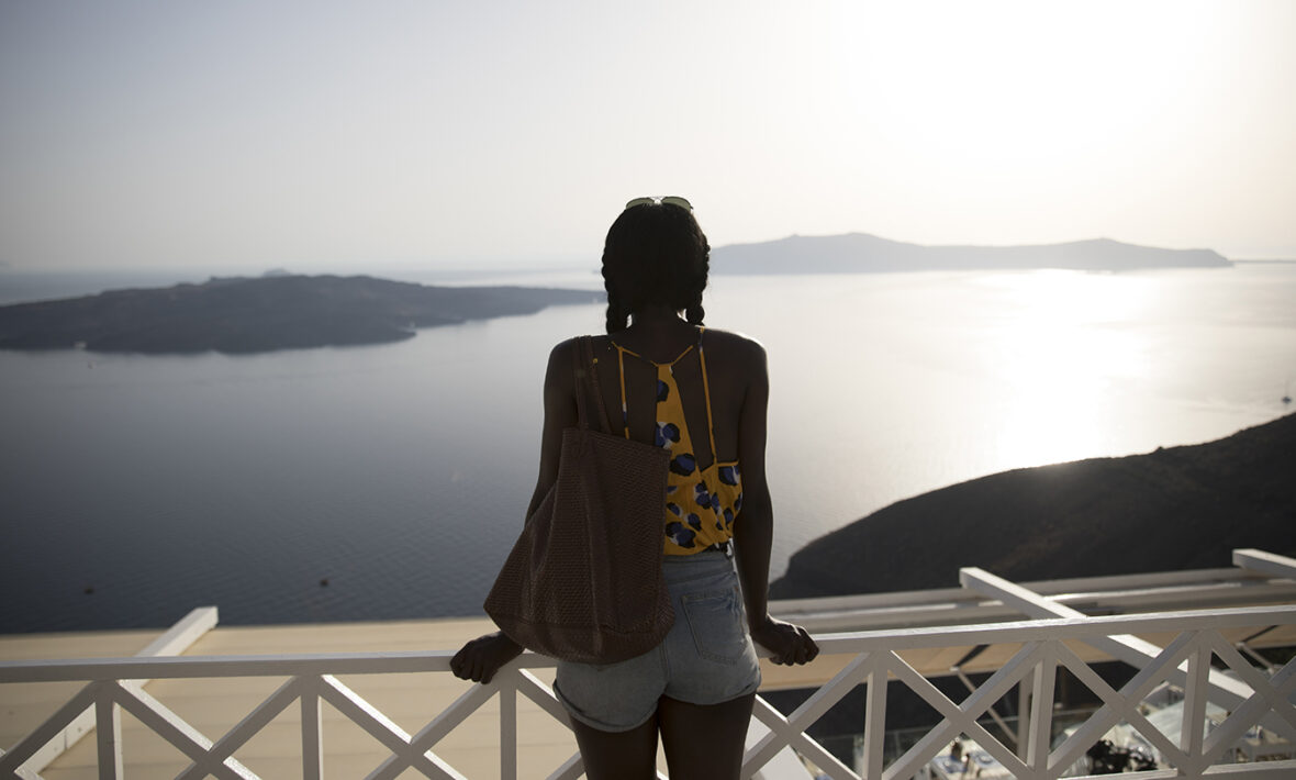 Girl-looking-onto-water-in-Santorini