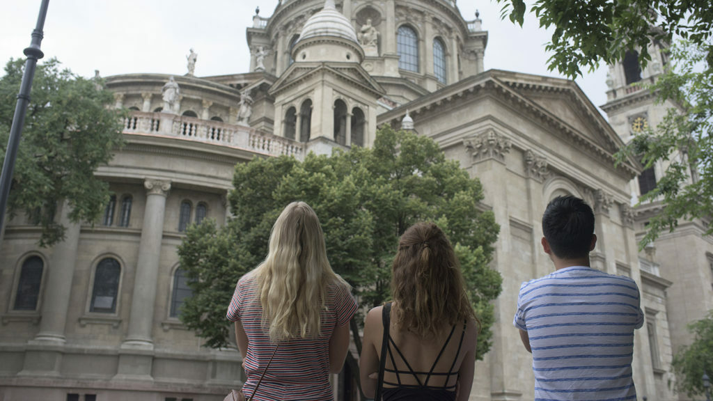 A group of people standing in front of an ornate building in Budapest.