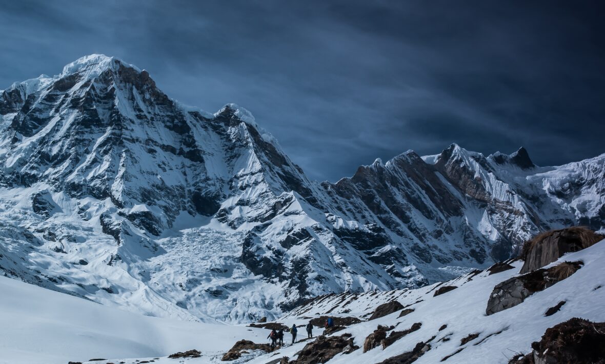 An adventurous group hiking up a snowy mountain during their thrilling travel expedition.