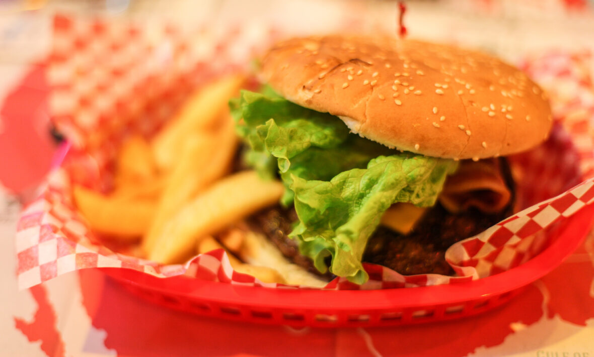 Indulge in a mouthwatering New York City burger and fries combo served in a rustic basket on a table.