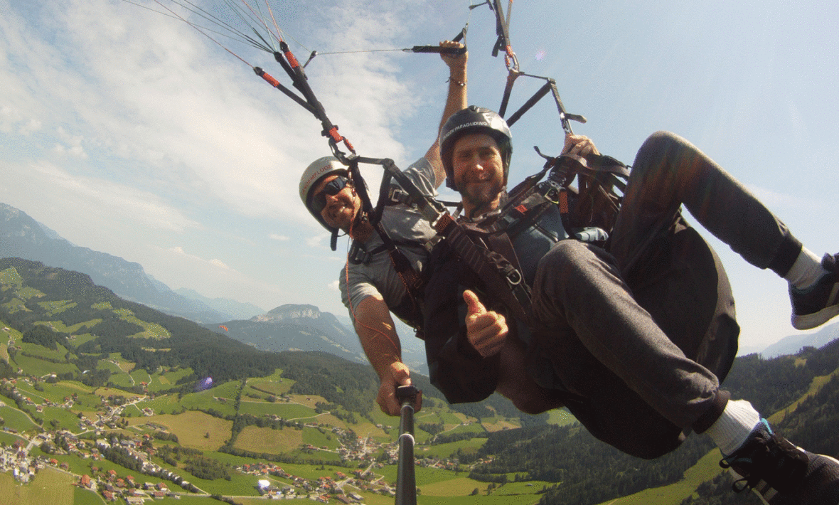 Two people paragliding over a mountain with short term memory loss.