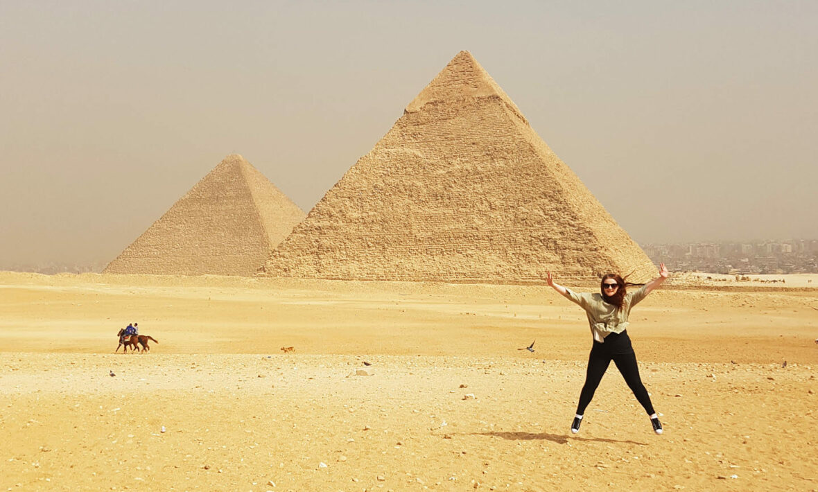 A woman is jumping in front of the UNESCO World Heritage Sites in Egypt.