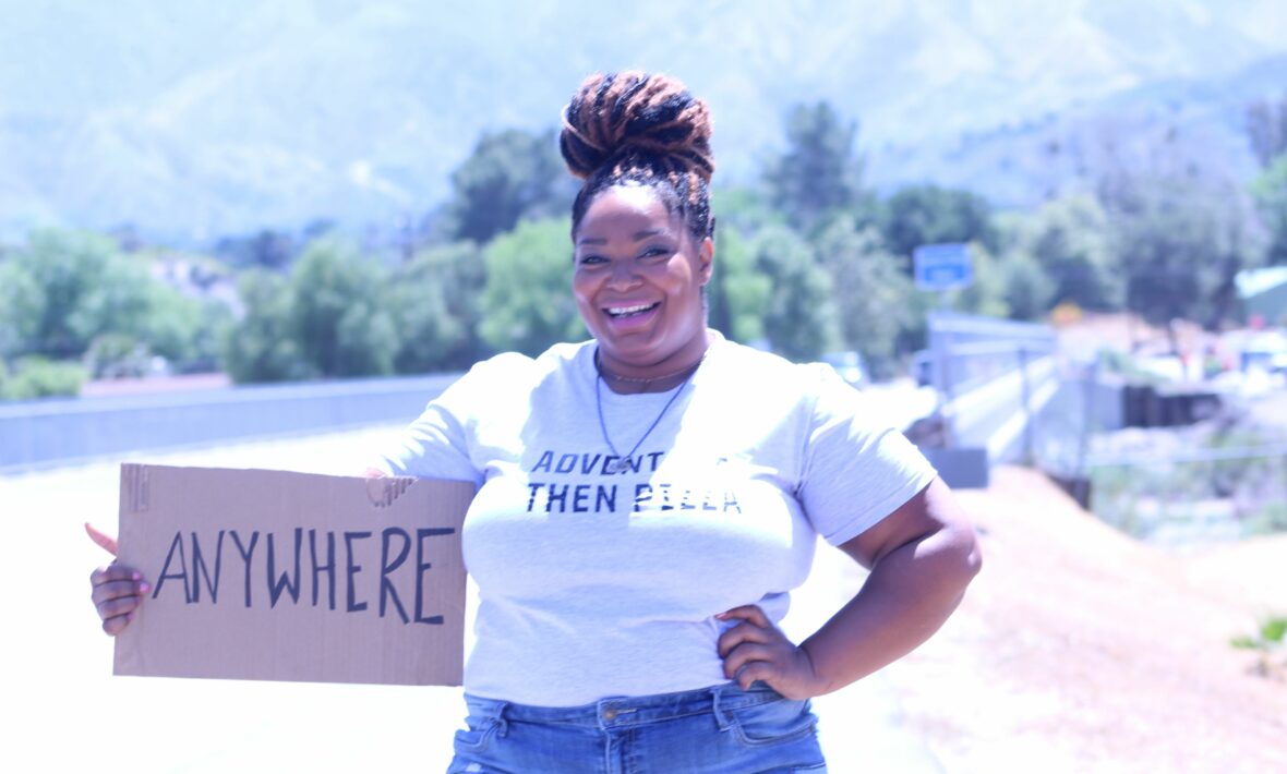 A woman promoting body positivity by holding up a sign that says i'm here for you.