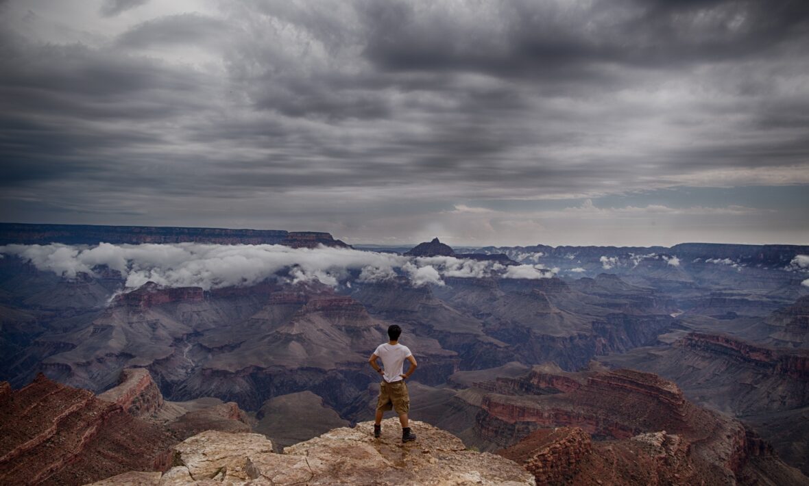 A man taking a professional selfie on a cliff overlooking the grand canyon.