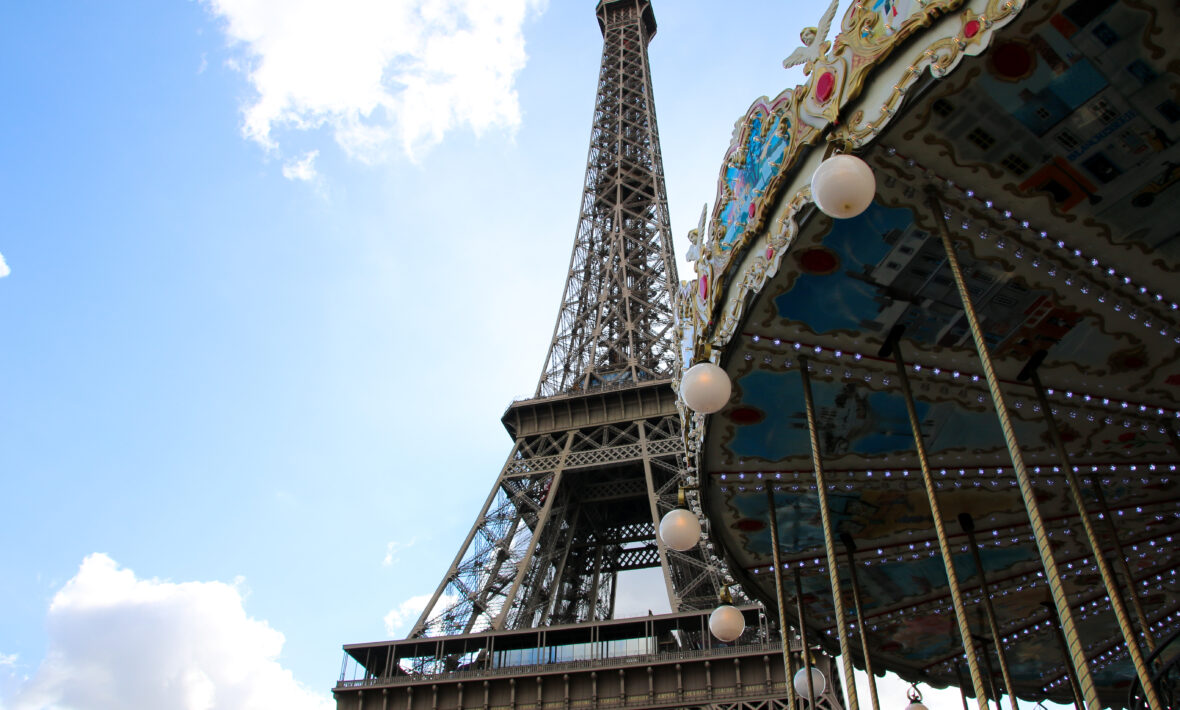 Looking up beyond a decorative carousel to the Eiffel Tower