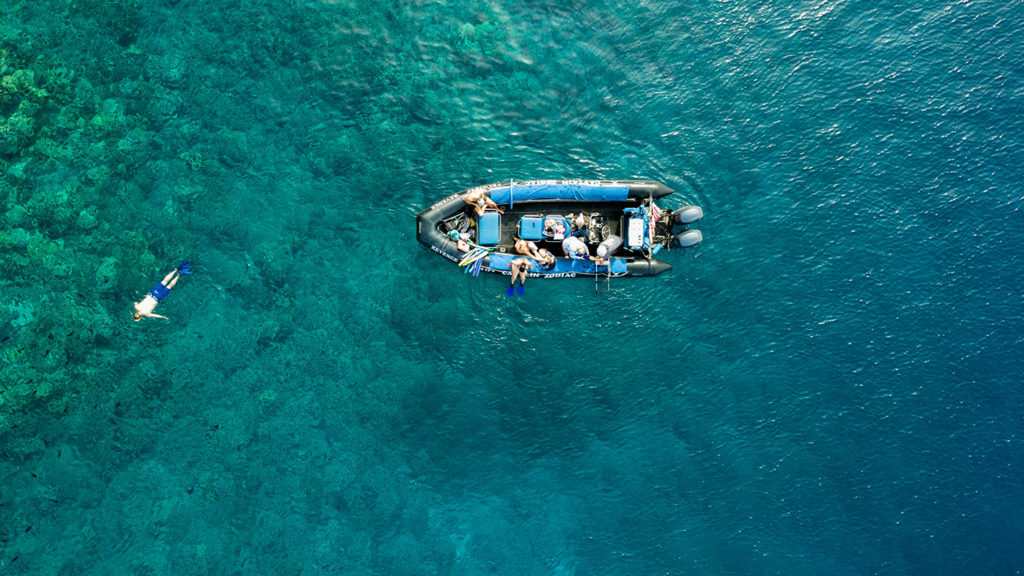 An aerial view of a boat in the ocean near Hawaii.