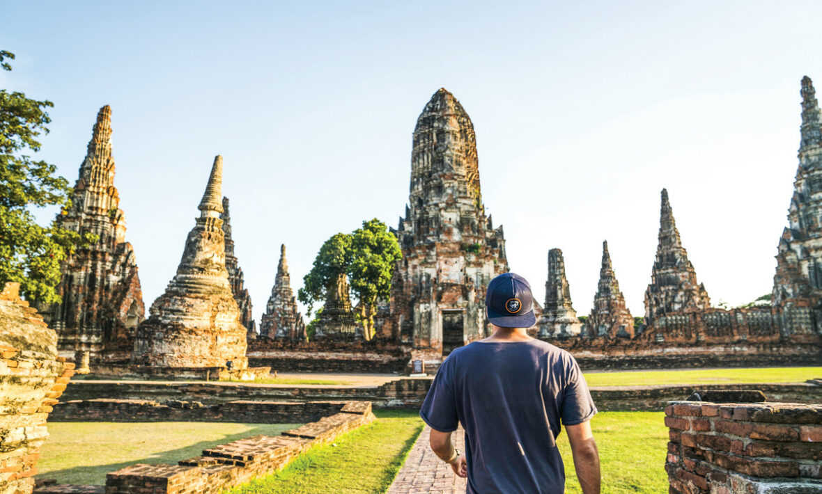 A man walking through a temple in Thailand.