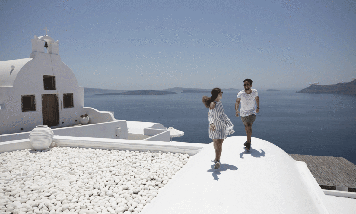 A couple enjoying a romantic escape on the roof of a white building.