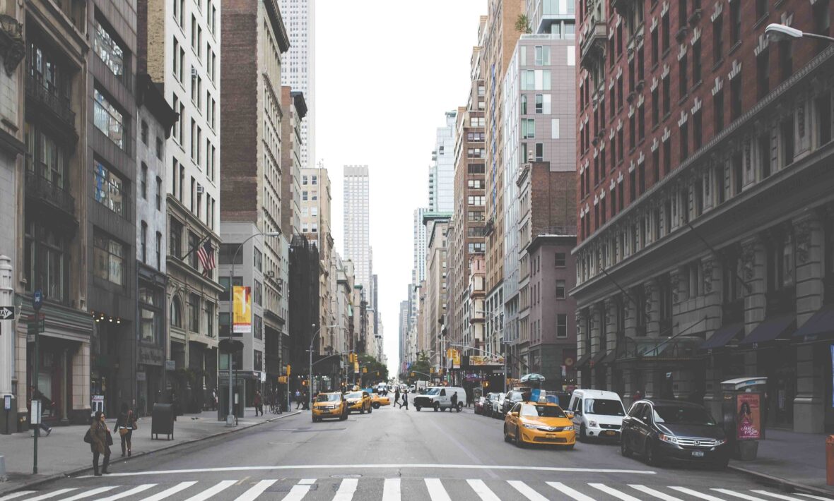 A bustling city street in Soho, New York, lined with towering buildings ideal for shopping enthusiasts.