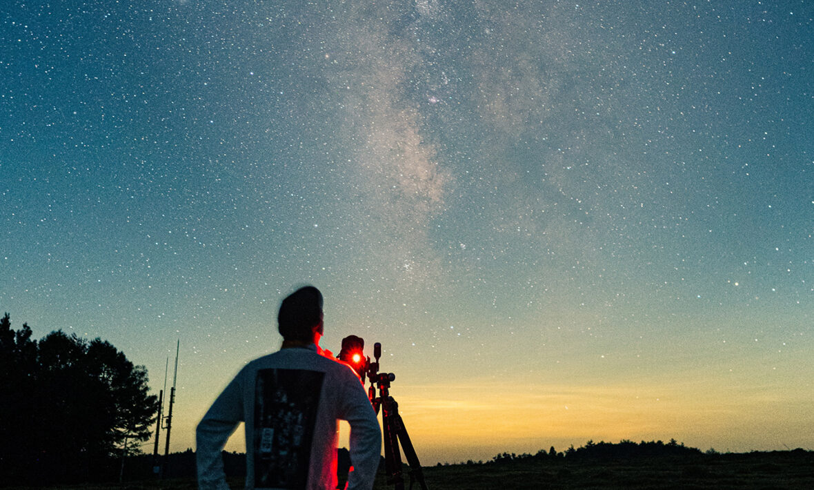 A man using a telescope to observe the sky for stargazing.