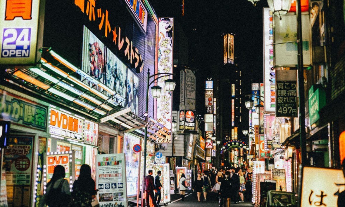 People walking down a street in tokyo at night.