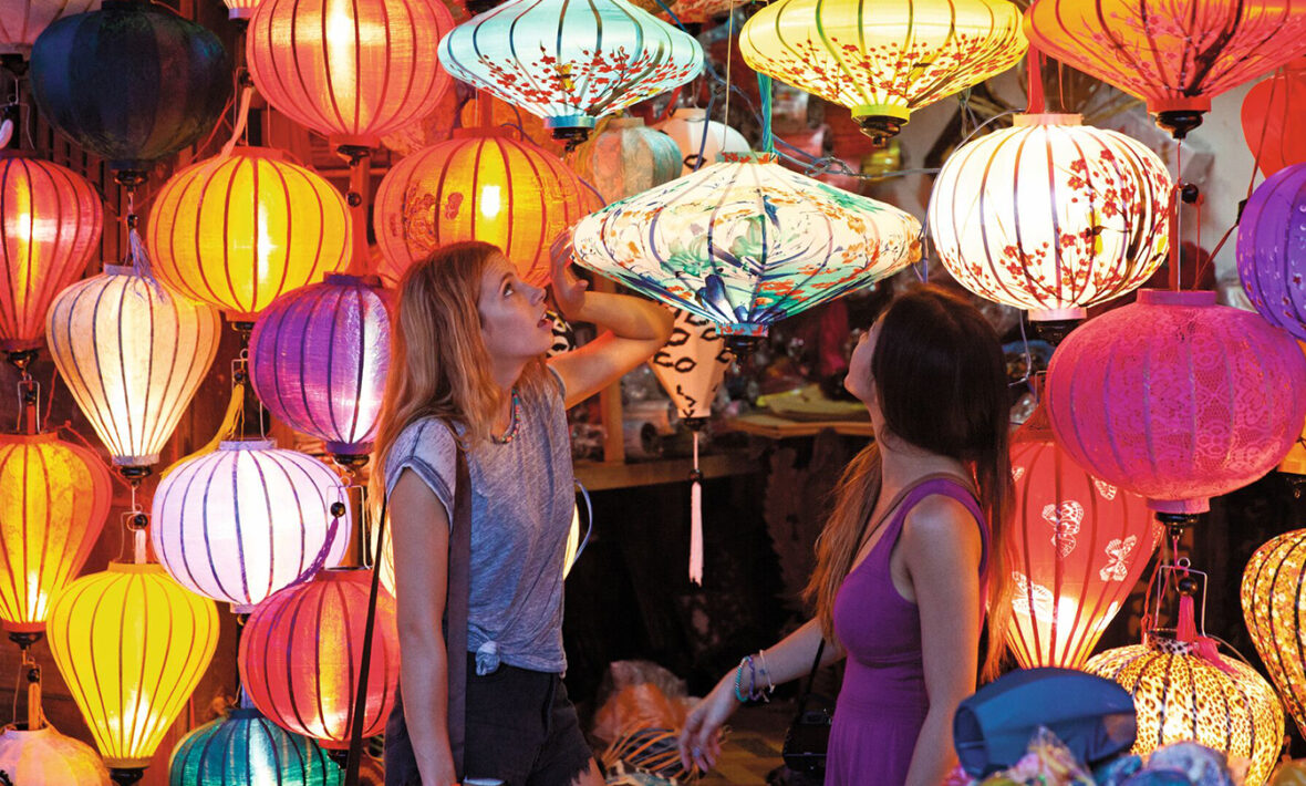 Two women experiencing Vietnam's colorful lantern market.