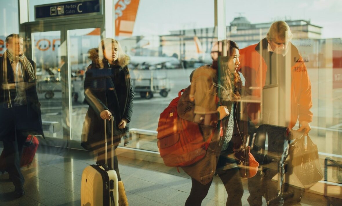 A group of people navigate the airport by themselves, walking through various terminals.