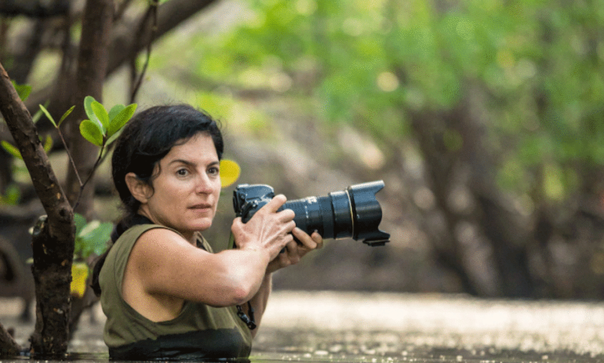 Ami Vitale capturing a photograph of a woman submerged in water.