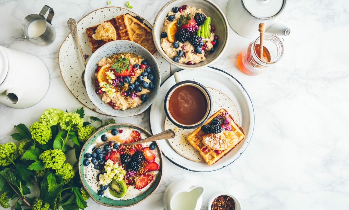 Vegan breakfast with waffles and fruit on a marble table.