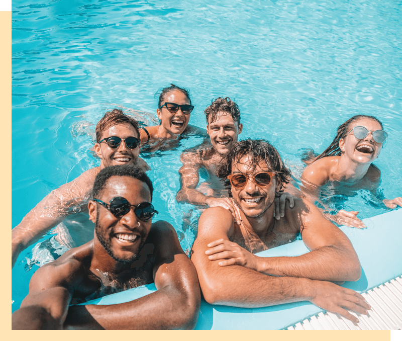 A group of friends in a pool taking a selfie.