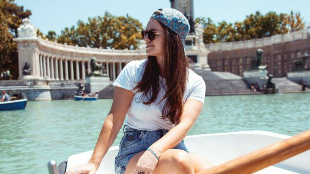 A woman named Danielle sitting on a boat in front of a fountain.