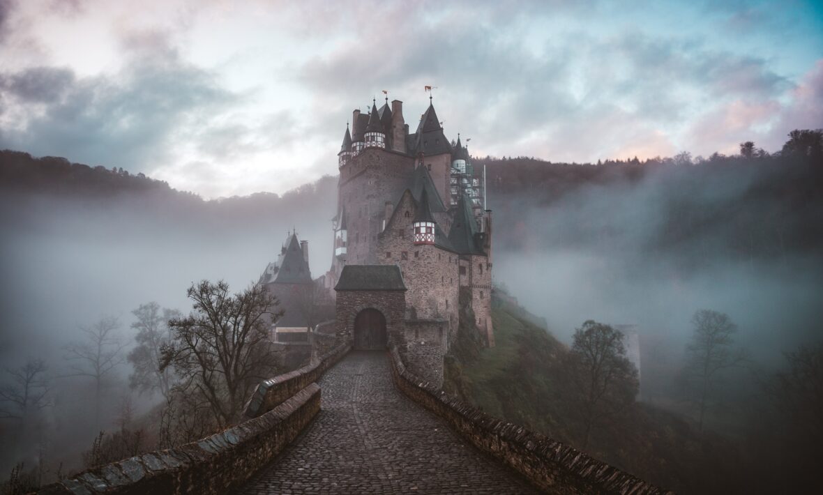 A haunted castle sits on top of a hill in the fog, making it one of the most haunted places in the world.