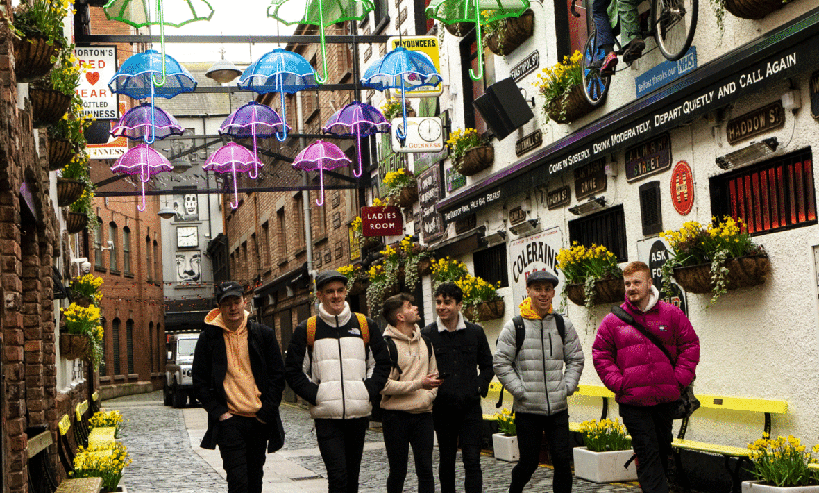 A group of cairde walking down a cobblestone street.