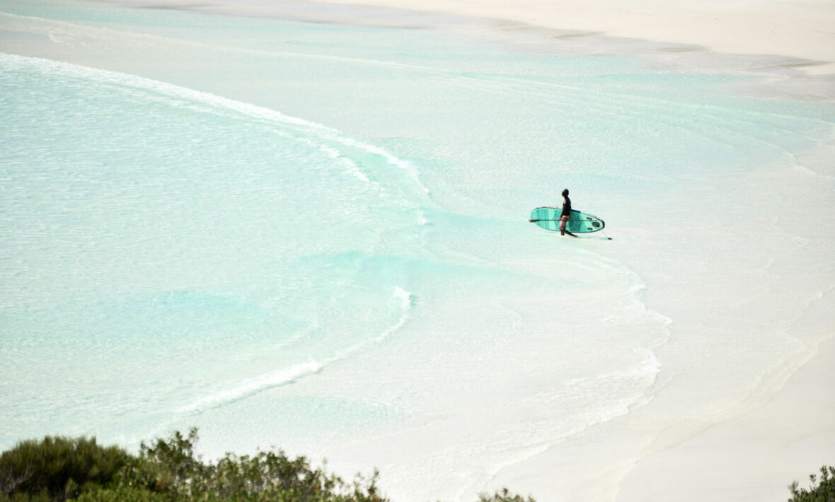 A person is surfing on a beach in Western Australia.