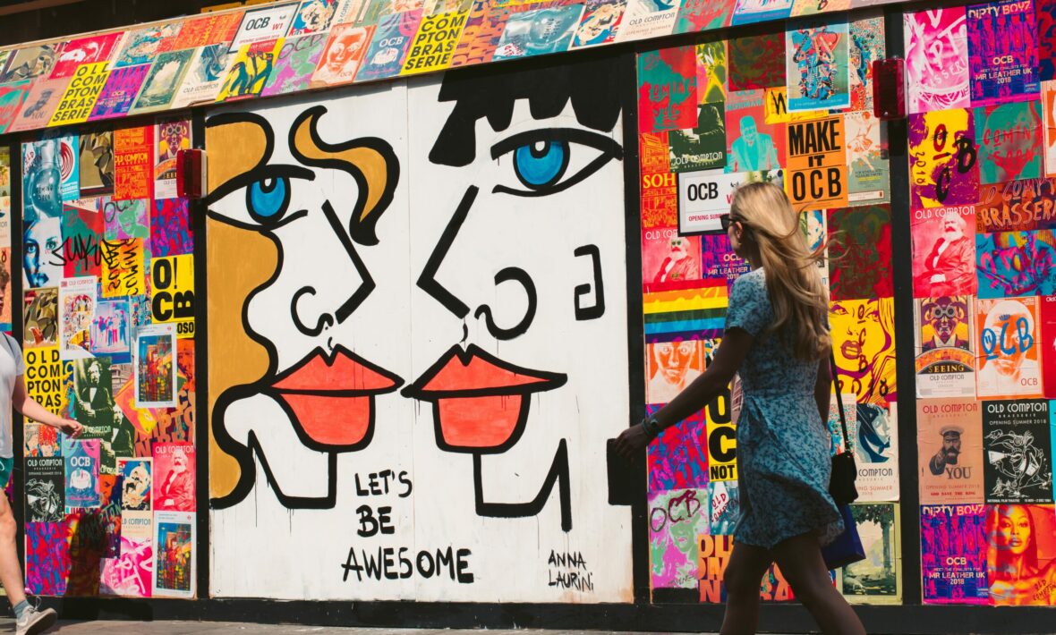 A woman walking past a mural depicting a couple in Great Britain.