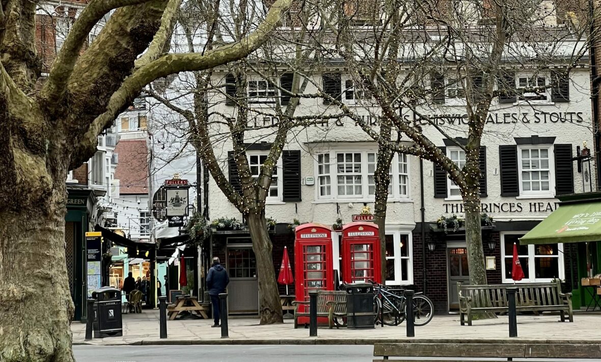 A ted lasso filming location in London featuring trees and a telephone booth.