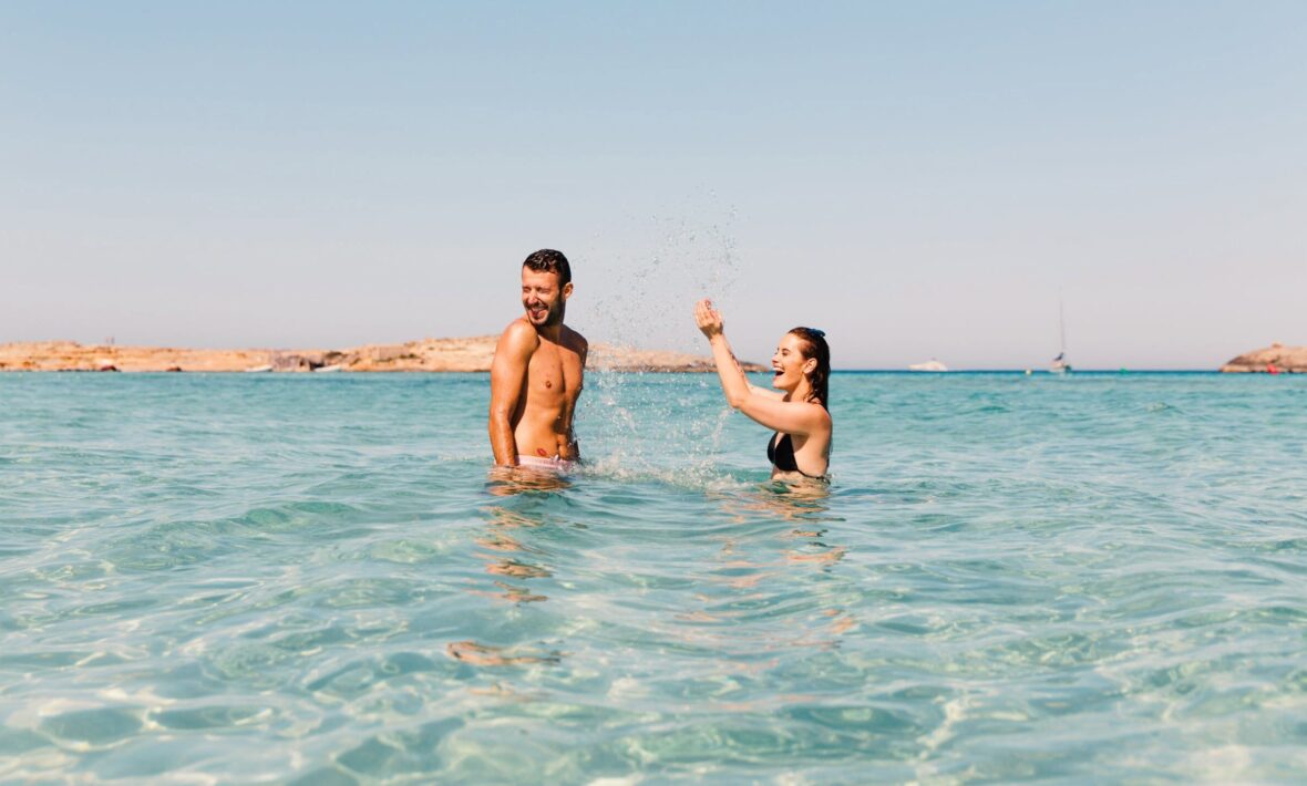 Image of a man and woman in the sea, playfully splashing about