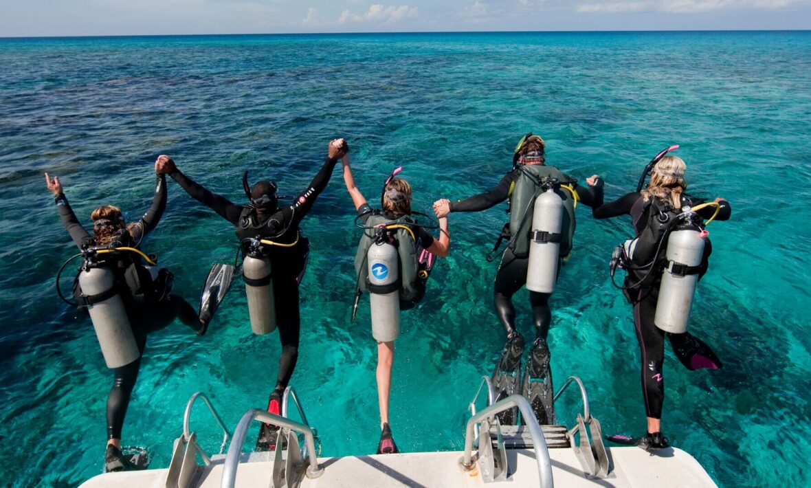 travellers hopping into the water to scuba dive