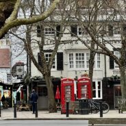 A ted lasso filming location in London featuring trees and a telephone booth.