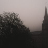 One of the best places to visit for Halloween is a hauntingly beautiful church, its steeple piercing through the dense fog.