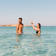 Image of a man and woman in the sea, playfully splashing about