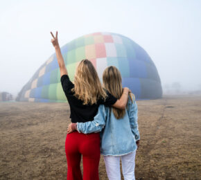 Two LGBTQ women enjoying a hot air balloon adventure.