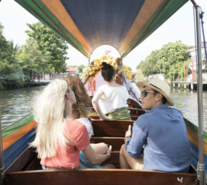 A group of people traveling down a canal in Asia.