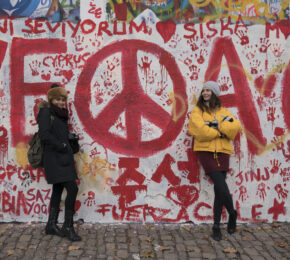 Political graffiti in red on a white exterior wall