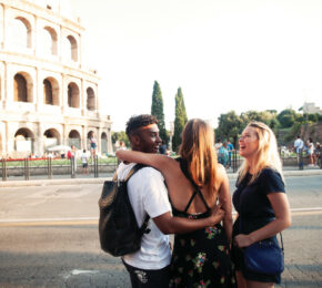 Three friends exploring Europe with Contiki standing in front of the Colosseum in Rome, Italy.