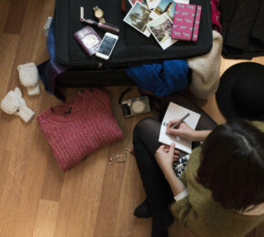 Girl writing with luggage